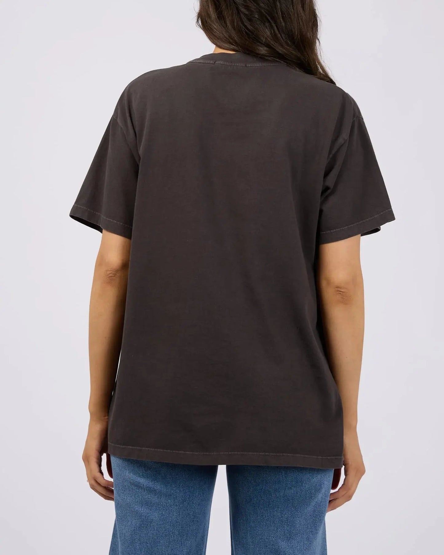 Person wearing a plain dark brown t-shirt on a light gray background