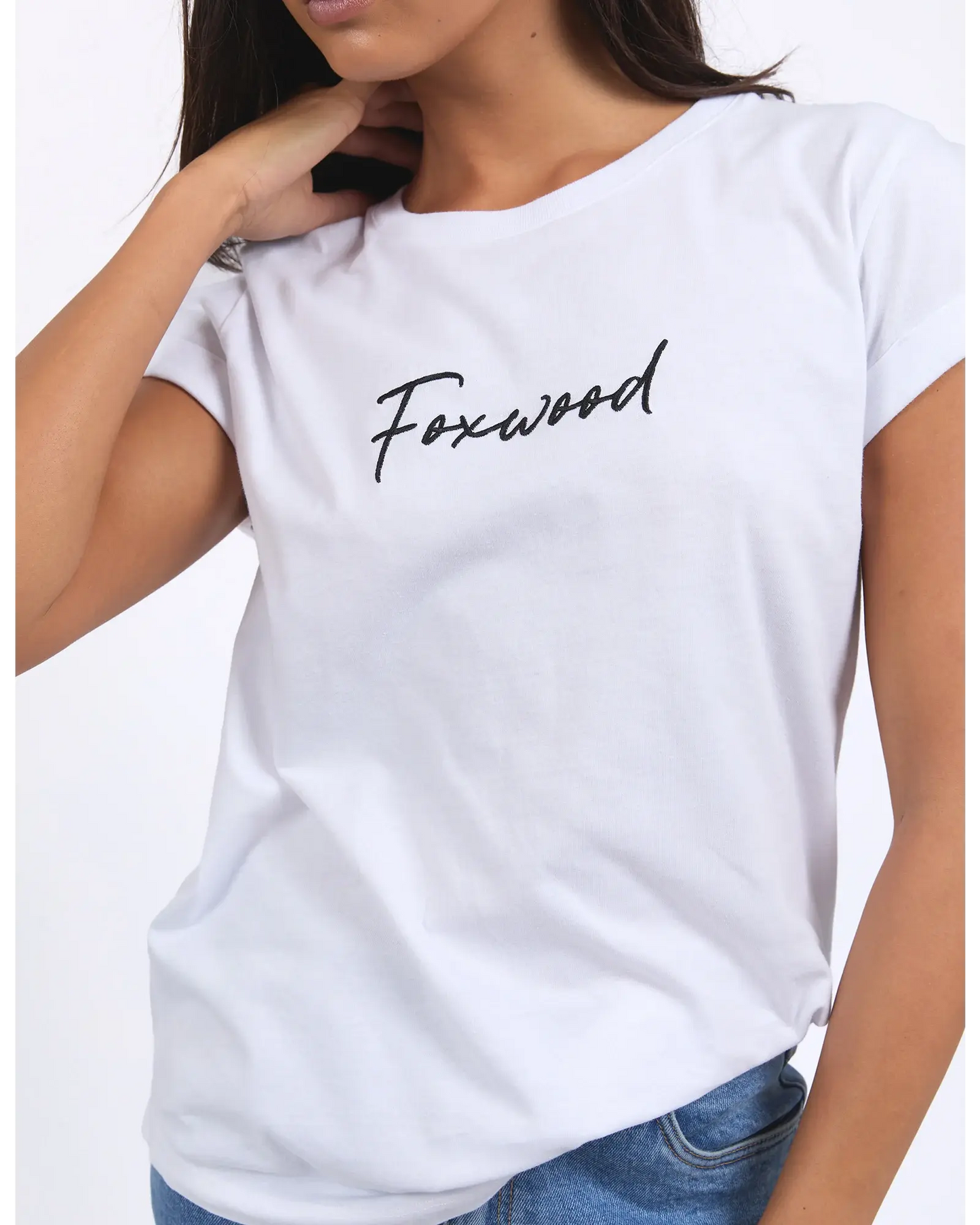 Person wearing a white t-shirt with 'Foxwood' printed on it against a plain background