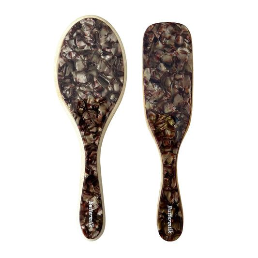Two wooden hairbrushes with tortoiseshell pattern on a white background.