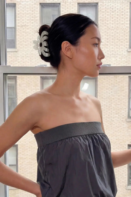 Woman wearing a strapless gray dress with a floral hair accessory, standing in front of a building. Buttermilk Rebekah Claw Clip Classic Pearl - The Rose Edit