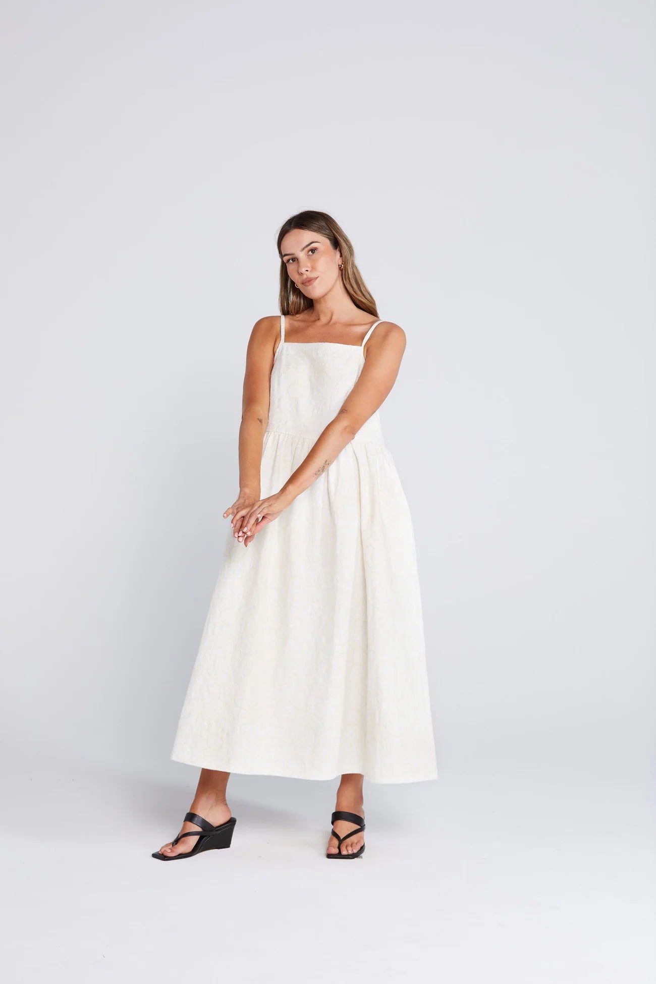 Woman wearing a white dress on a plain background