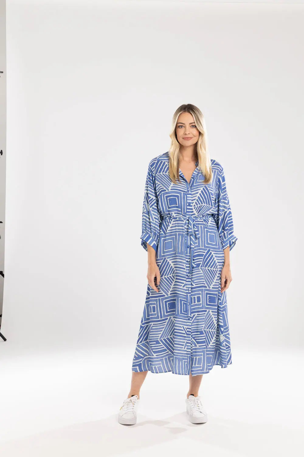 Woman wearing a blue geometric patterned dress on a white background