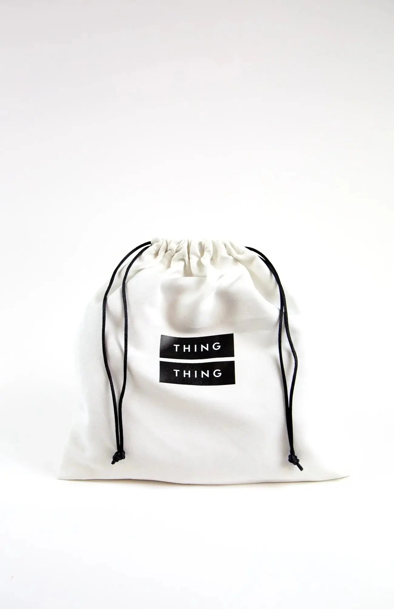 White drawstring bag with 'THING' label on a white background