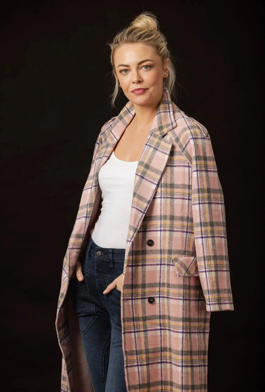 Woman wearing a plaid coat against a black background