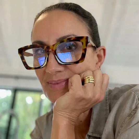 Person wearing tortoiseshell sunglasses with a blurred background