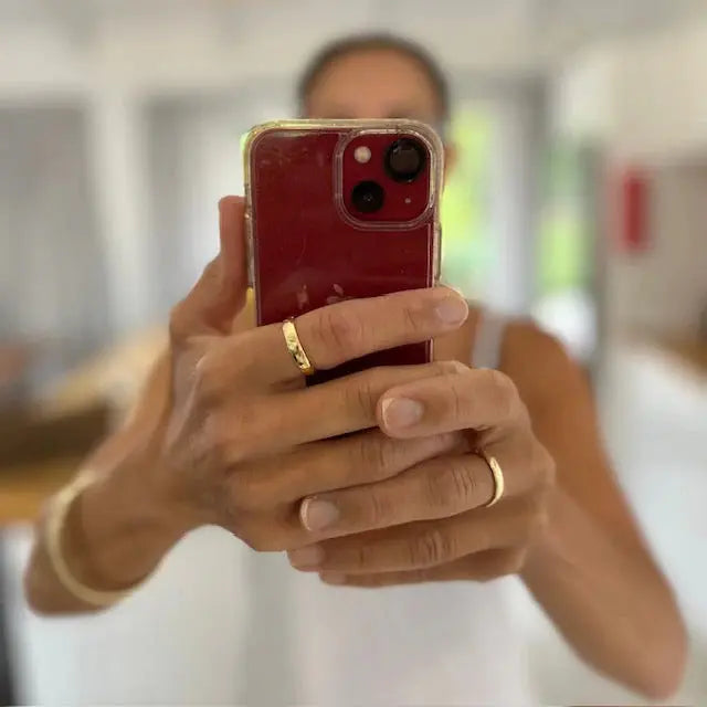 Person holding a red phone with a blurred background