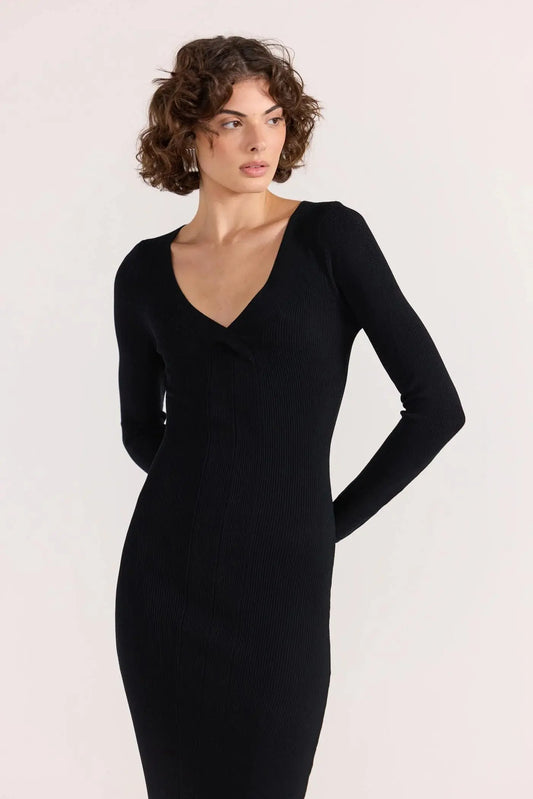 Woman wearing a black dress against a white background