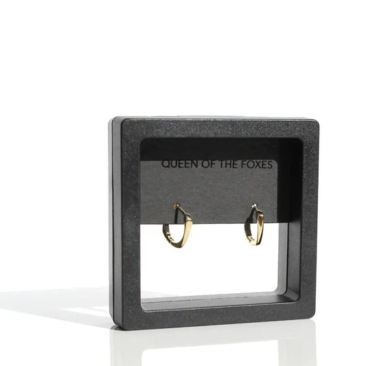 Black jewelry display card with gold earrings on a white background