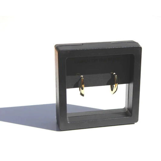 Black earring display stand with gold earrings on a white background