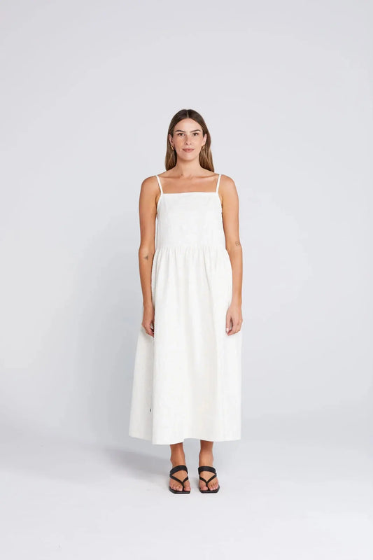 Woman wearing a white dress on a light gray background