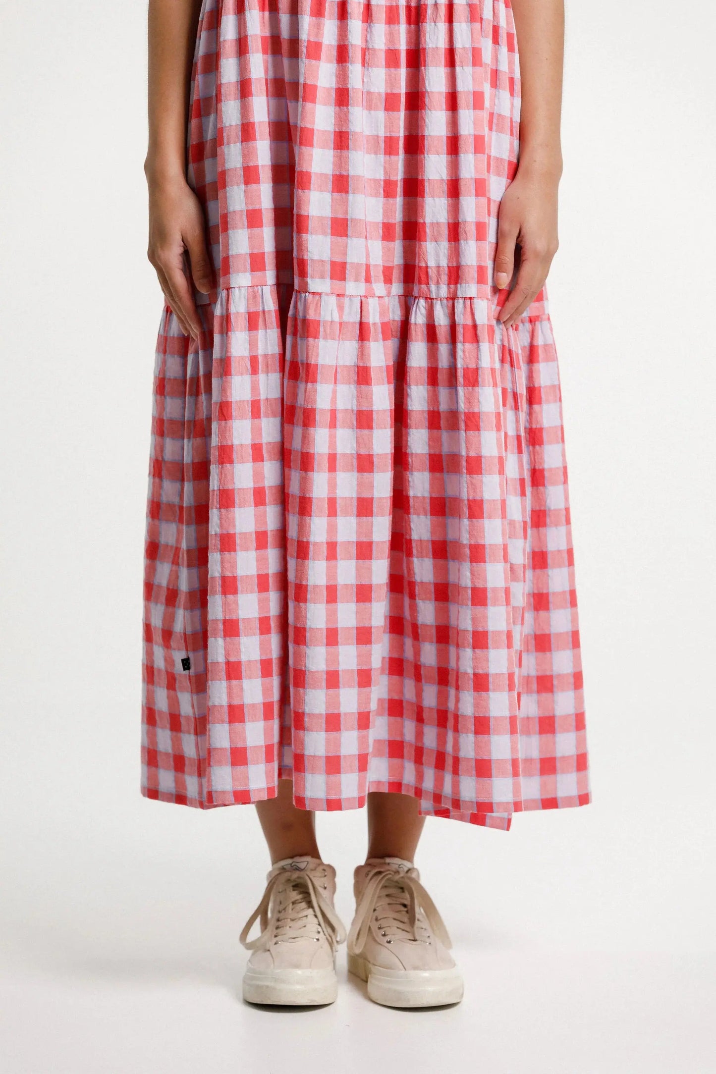 Person wearing a red and white checkered dress on a white background