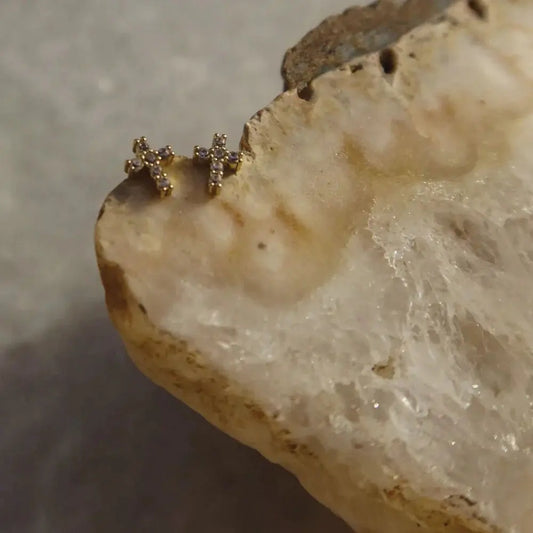 Gold cross earrings on a piece of bread