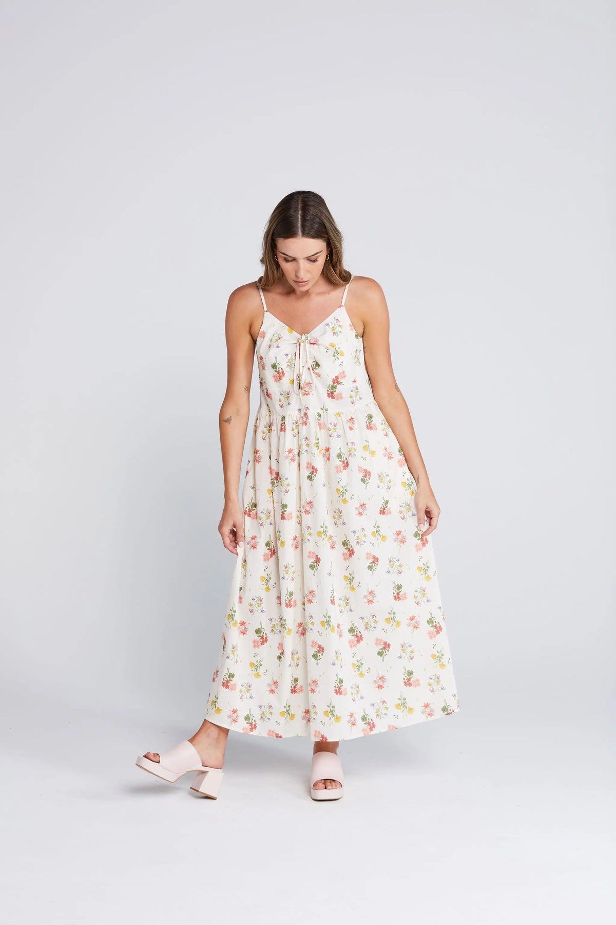 Woman wearing a floral dress on a white background. Zinnia Dress Summer Haven Front View - The Rose Edit