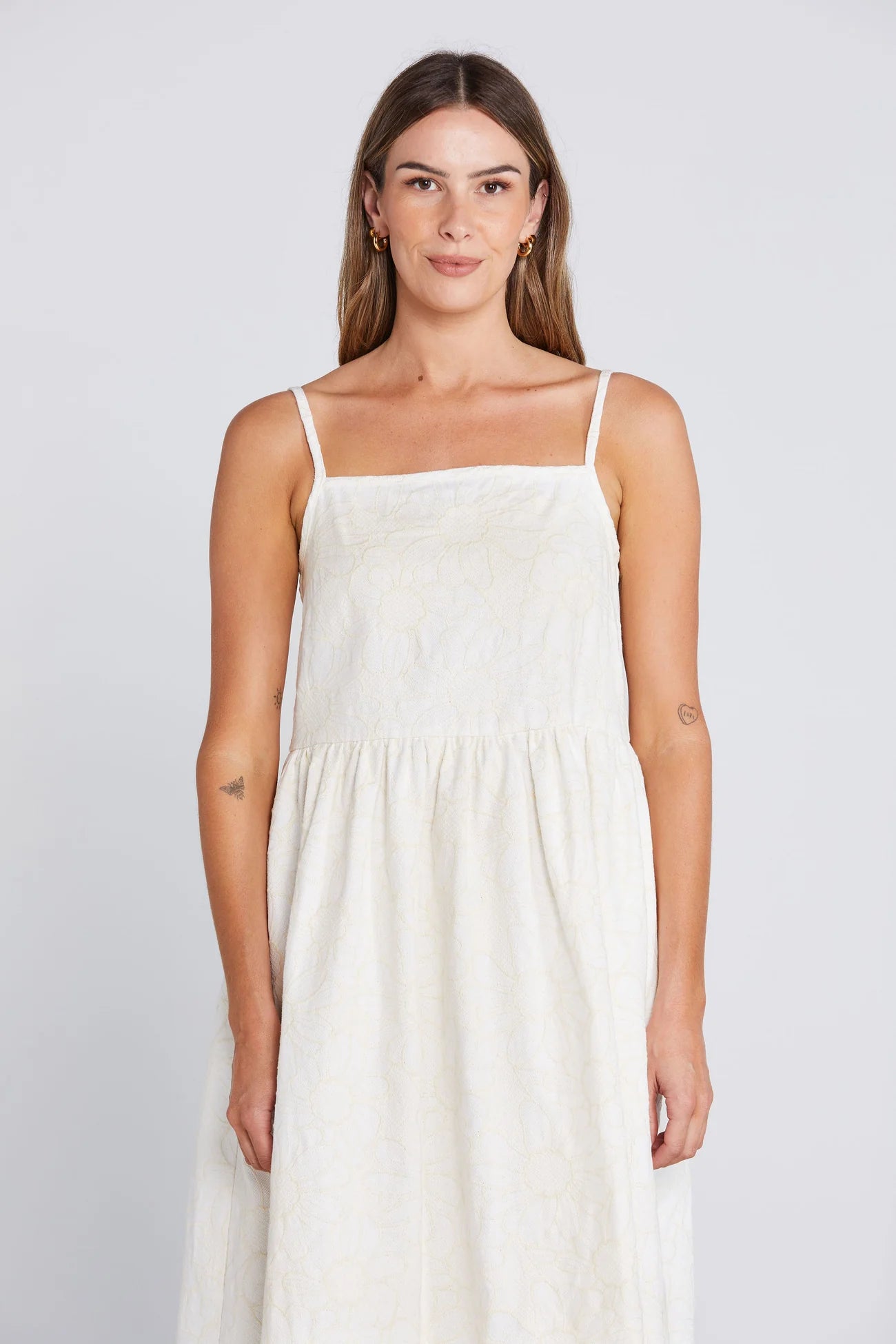 Woman wearing a white dress against a plain background