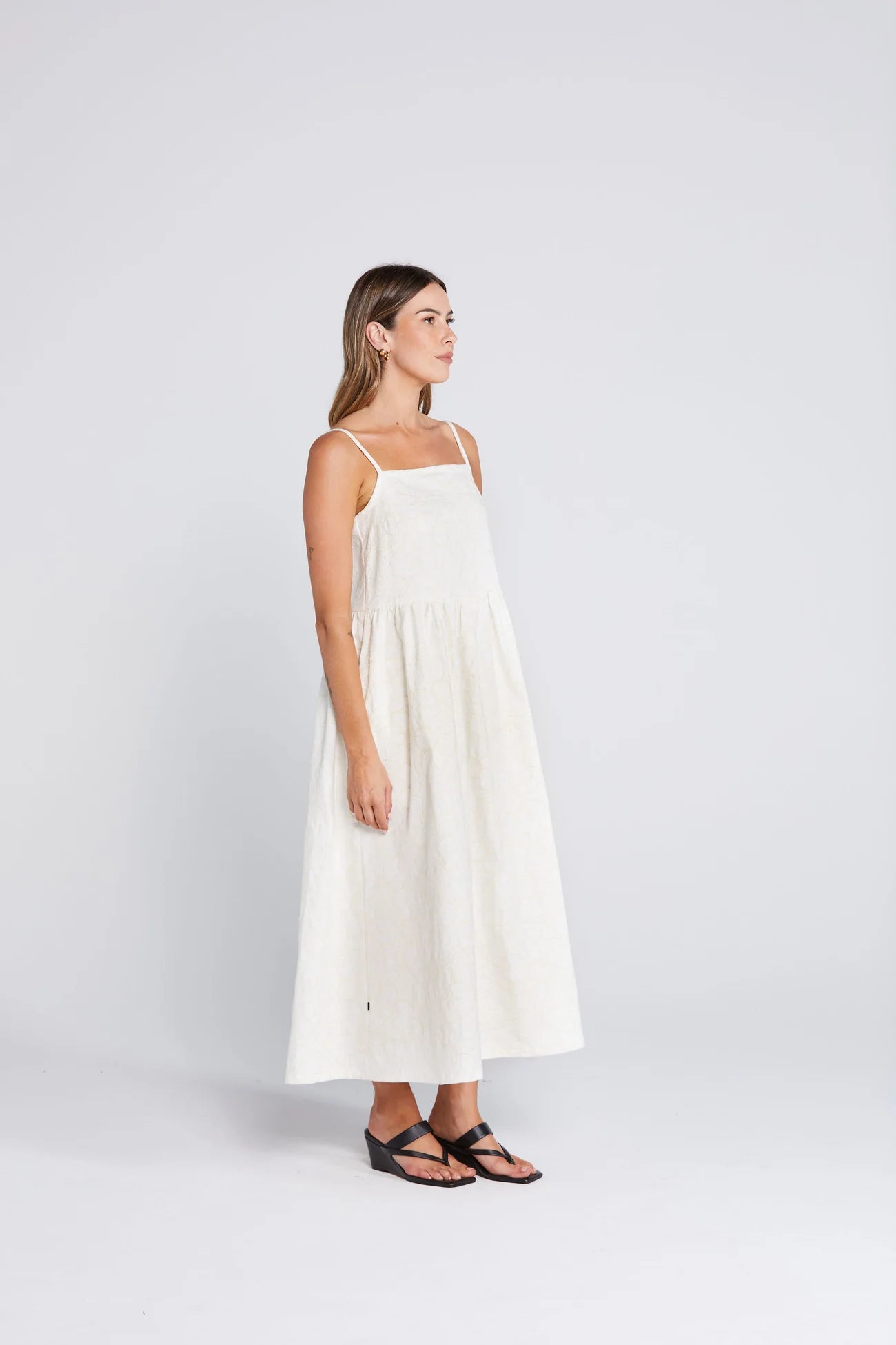 Woman wearing a white dress on a plain background