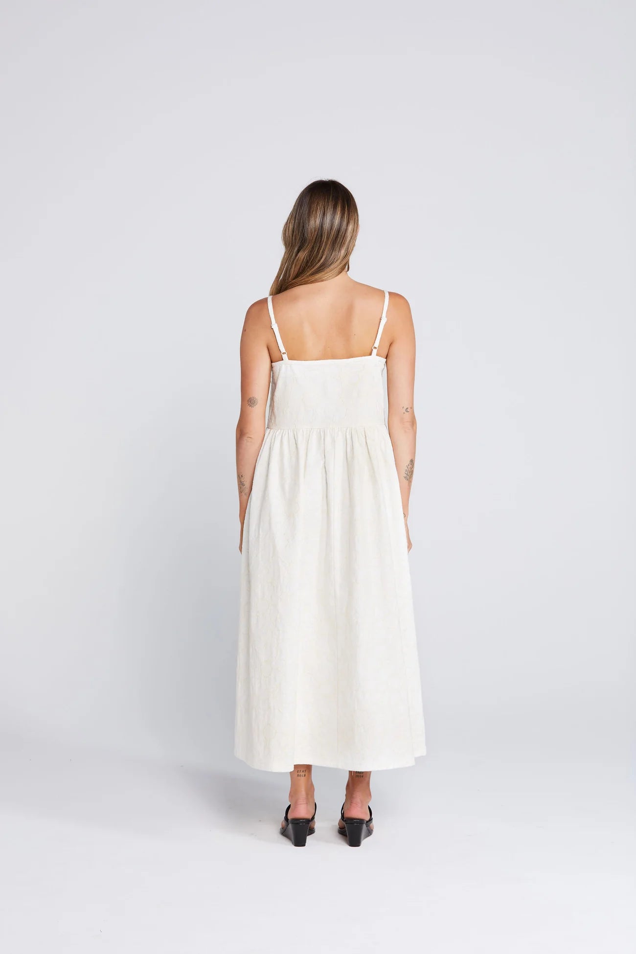 Woman wearing a white dress on a plain background