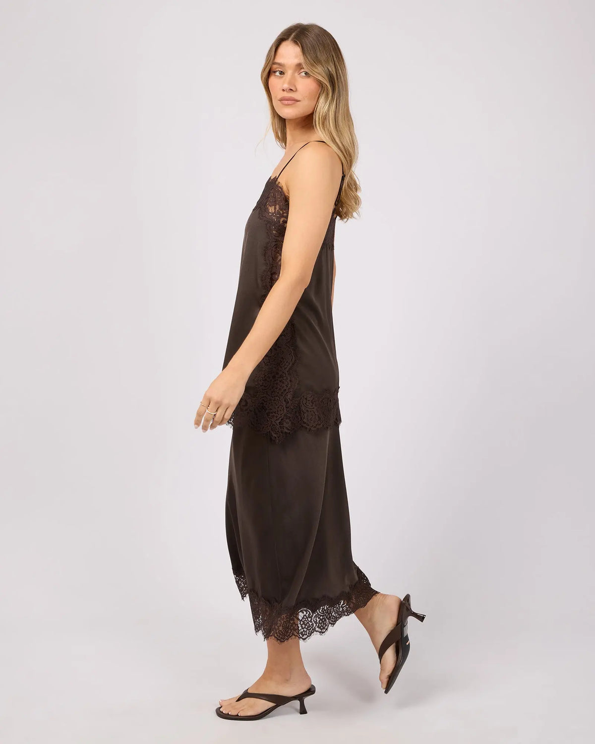 Woman wearing a brown slip top and skirt with lace details on a white background. Hava Lace Skirt Coffee - The Rose Edit