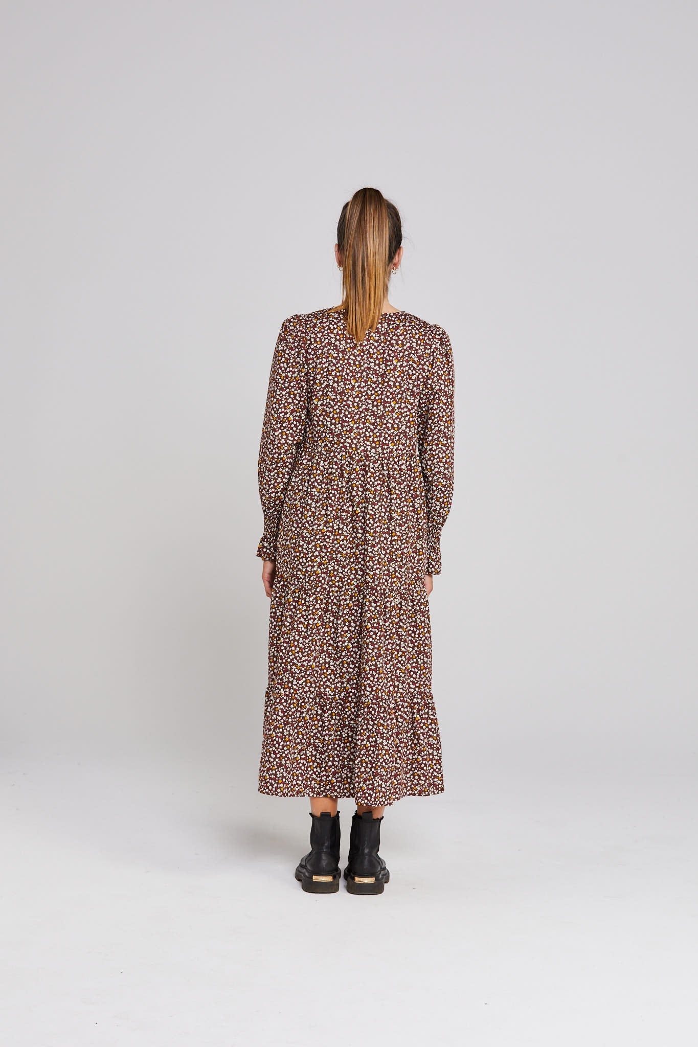 Person wearing a patterned dress on a white background