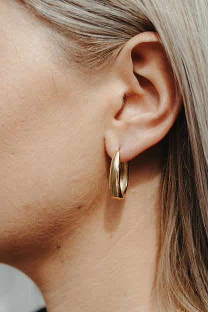 Gold Maeve Hoop earring worn on model — close-up ear and jaw shot, blonde hair