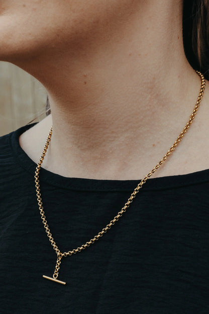 Gold chain necklace with a pendant on a person wearing a black top. Large T Bar Necklace KatyB Jewellery