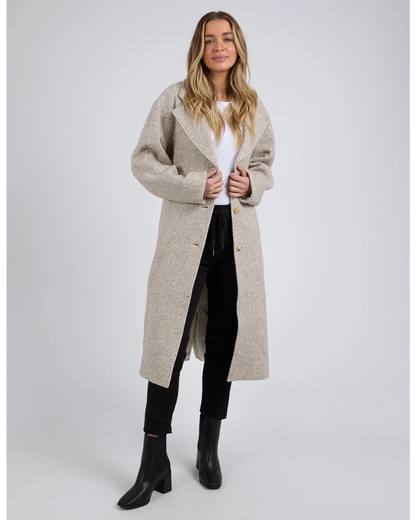 Woman wearing a beige long coat on a white background