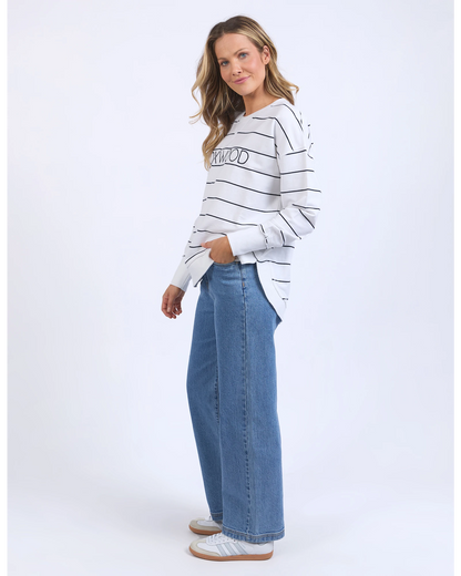 Woman wearing a striped sweater and jeans on a white background