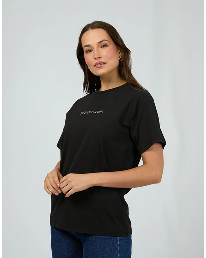 Woman wearing a black t-shirt with text on a plain background