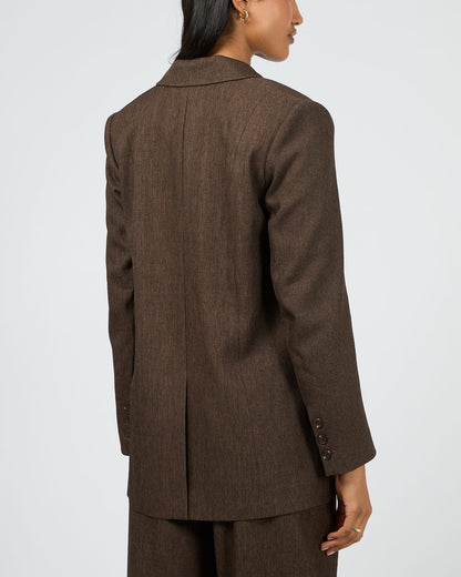 Brown suit jacket worn by a person on a white background