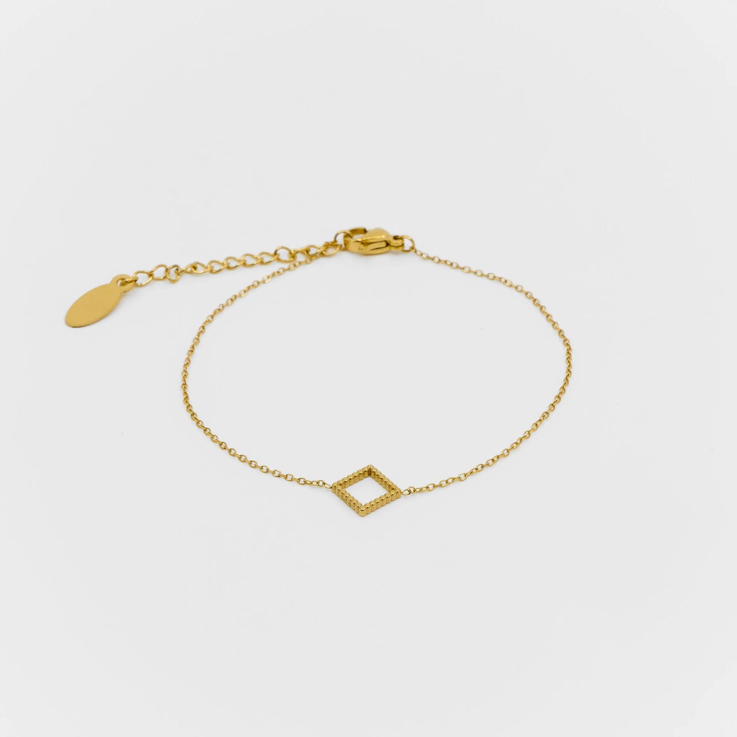 Gold bracelet with a geometric design on a light gray background