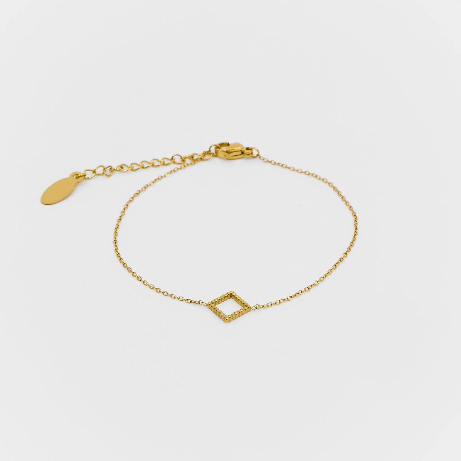 Gold bracelet with a geometric design on a light gray background
