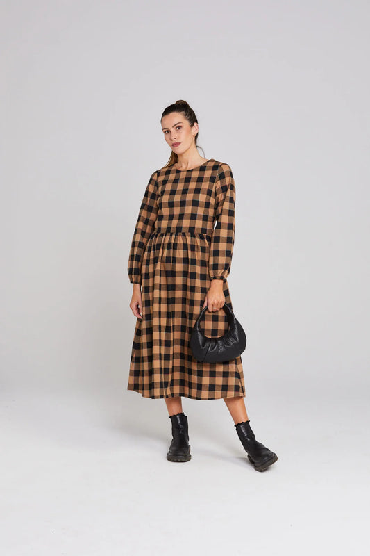 Woman wearing a brown and black checkered dress on a white background