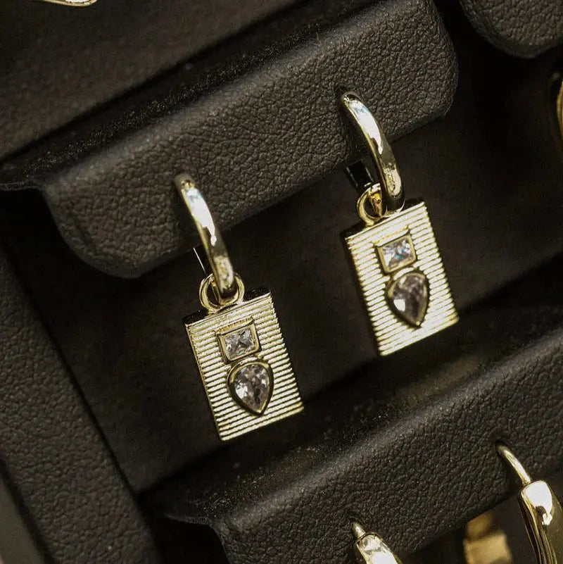 Gold pendants with gemstones on a black jewelry display