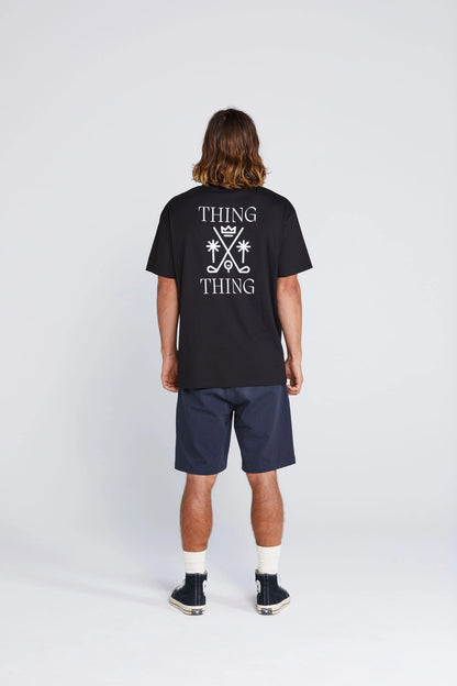 Person wearing a black t-shirt with 'THING THING' text on the back, standing against a white background