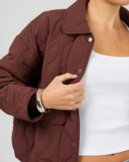 Brown jacket worn by a person on a white background. Archer Stitched Jacket Cherry - The Rose Edit