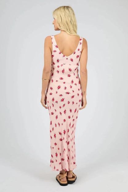 Woman wearing a floral dress on a white background.Scarlett Maxi Dress Print - The Rose Edit