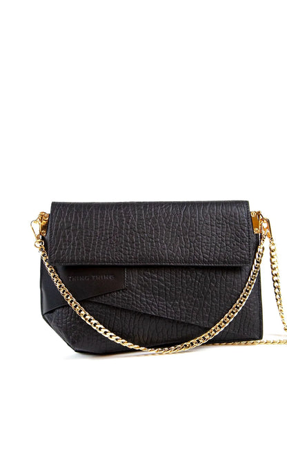 Black textured handbag with a gold chain strap on a white background