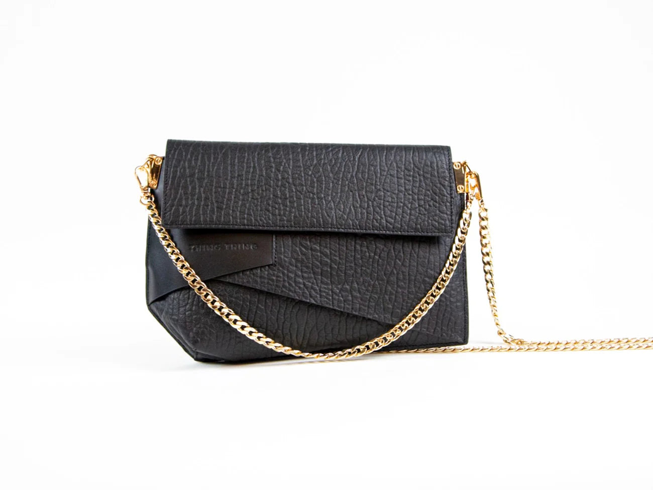 Black handbag with gold chain on a white background
