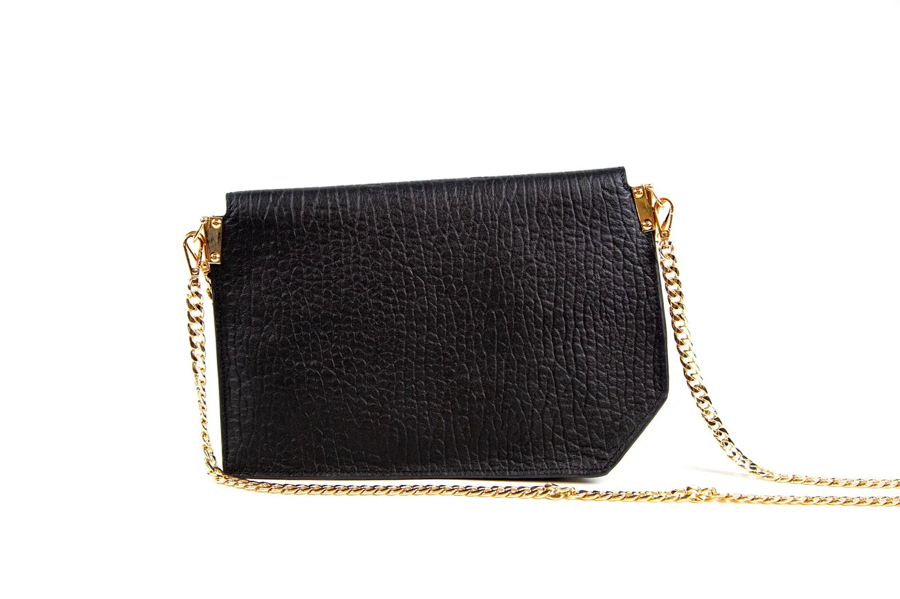 Black handbag with a gold chain strap on a white background