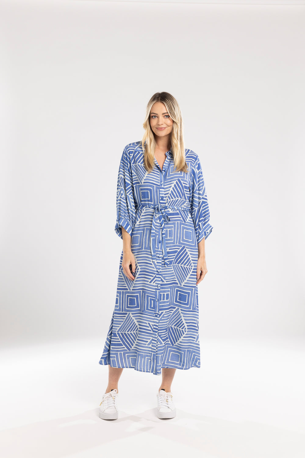 Woman wearing a blue geometric patterned dress on a white background