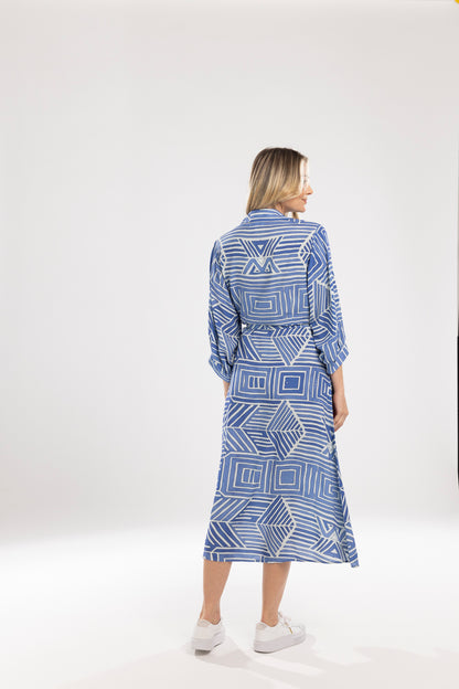 Woman wearing a blue geometric patterned dress on a white background