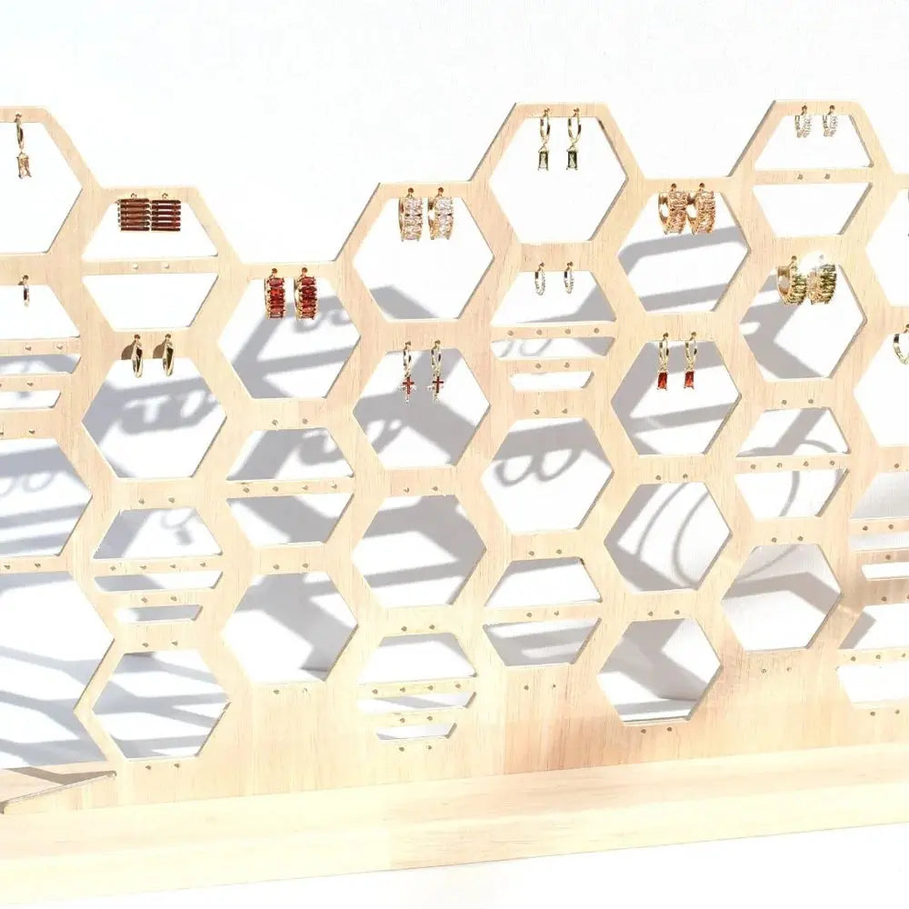 Wooden earring holder with honeycomb design on a white background