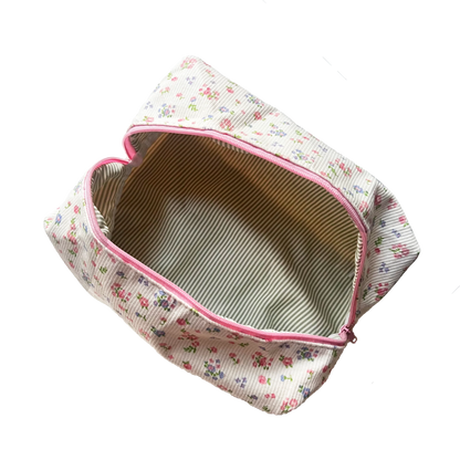 Floral-patterned pouch with pink zipper on a white background. Buttermilk Grace Carry All Bag Forget-Me-Not - The Rose Edit