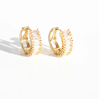 Gold hoop earrings with a textured design on a white background.The Perfect Huggies Diamond - The Rose Edit