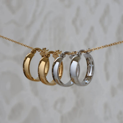 Gold and silver Aria Hoops hanging on chain — both colourways side by side
