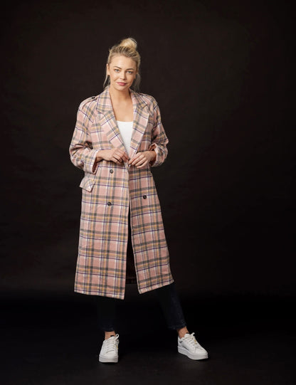 Woman wearing a plaid coat against a black background