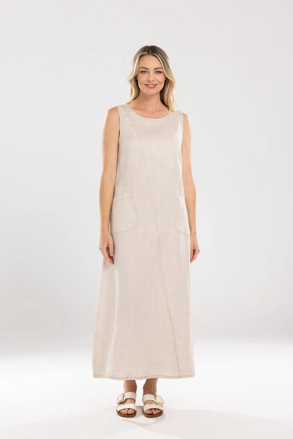 Woman wearing a beige sleeveless dress on a white background