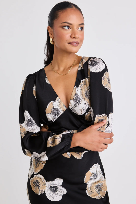 Woman wearing a black floral dress against a white background