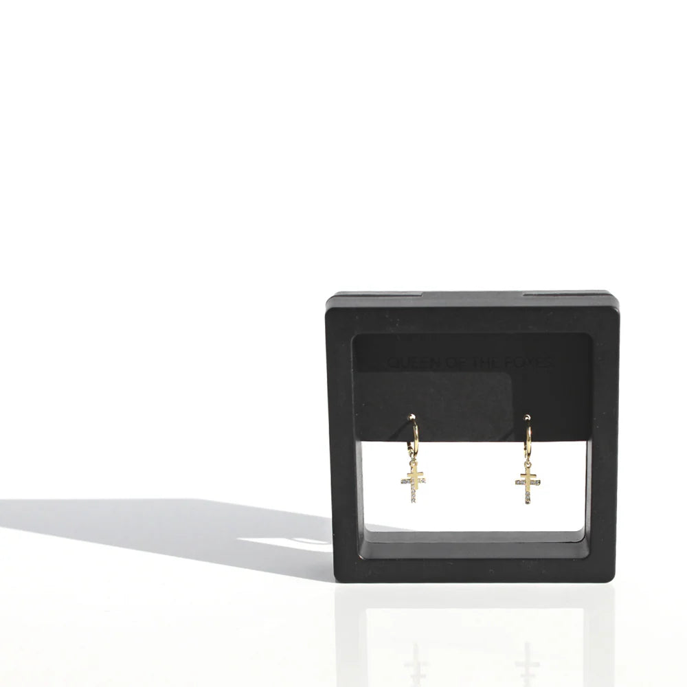 Black square earring display with gold earrings on a white background