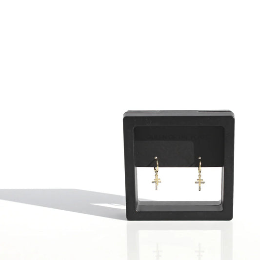 Black square earring display with gold earrings on a white background