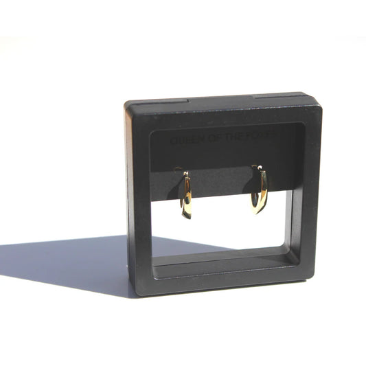 Black earring display stand with gold earrings on a white background